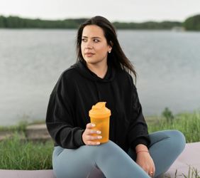 A person drinking water from a reusable bottle after exercise.