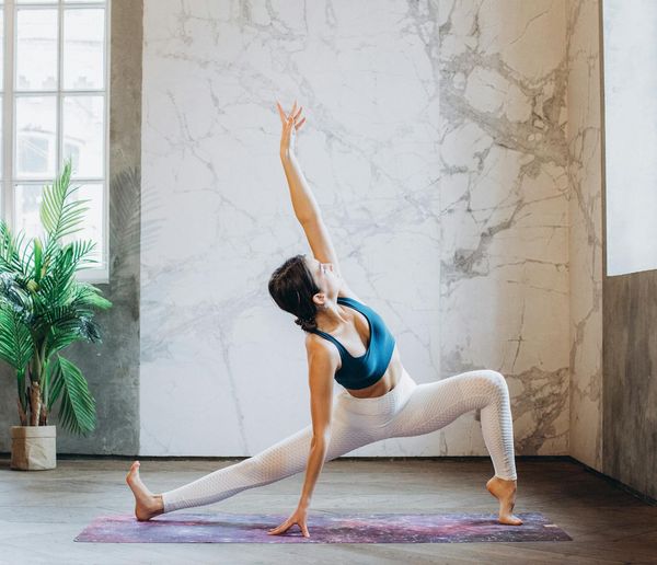 Person stretching in a spacious, sunlit studio.